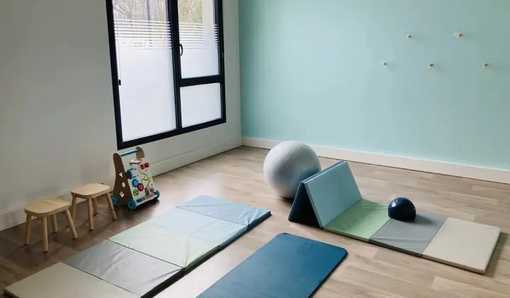 Salle d’activités : tapis de sport et de motricité, ballon et petits tabourets d’enfants